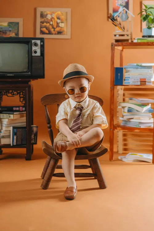 enfant_en_costume_assis_sur_une_chaise_qui_joue_a_des_jouets_educatifs